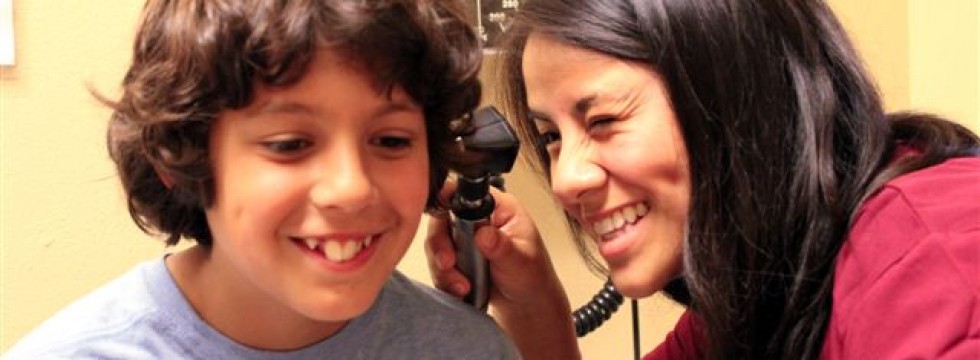 Nurse giving young boy an ear exam